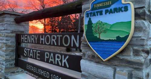 Sign for Henry Horton State Park in Tennessee, with a colorful sunset in the background. Established 1964.