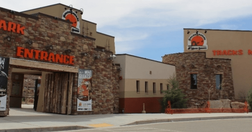 Entrance to a park featuring stone architecture and signage for "Tracks N' Trails" and "Park Entrance."