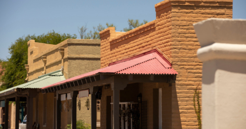 Historic buildings with colorful roofs and adobe-style architecture under a clear blue sky.