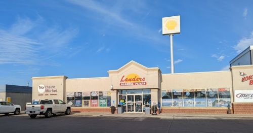 A storefront with "Landers" signage, featuring various advertisements and a Shell gas station sign above.