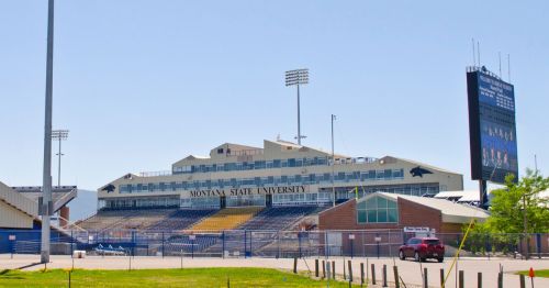 Montana State University stadium with seating, scoreboard, and clear blue sky in the background.