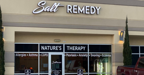 Exterior of Salt Remedy store, featuring a sign and windows displaying services for various health conditions.