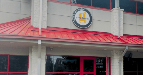 Exterior of Giordano's Hall of Fame, featuring a red roof and large sign.