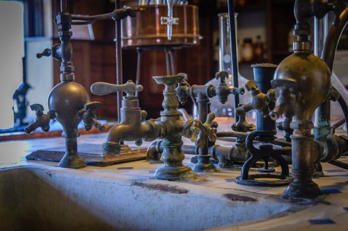 A collection of vintage brass faucets and valves on a countertop, showcasing intricate designs and textures.
