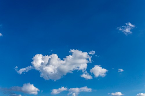 A clear blue sky with a few fluffy white clouds scattered throughout.
