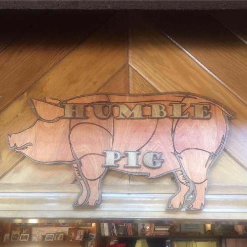 Wooden sign featuring a pig silhouette with the words "Humble Pig" carved above it.