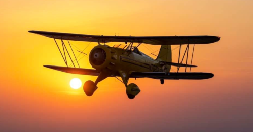 A vintage yellow biplane flying against a vibrant sunset, with the sun partially visible on the horizon.