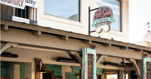 A building exterior featuring a sign for "The Holy Grill at the Pier" and colorful decor.