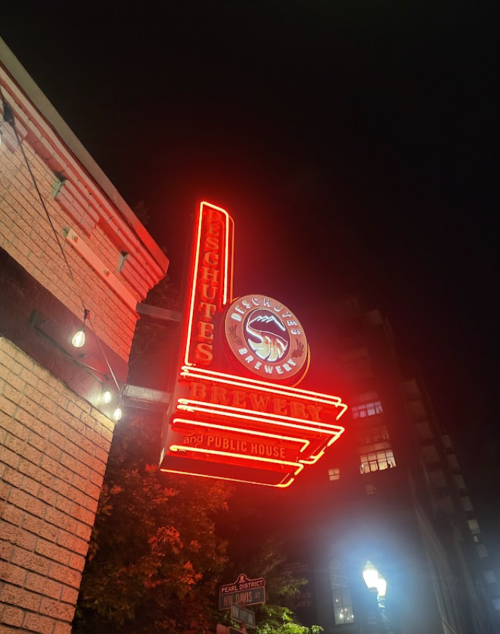 Neon sign for a brewery and public house at night, featuring the name "Lighthouse Brewery."
