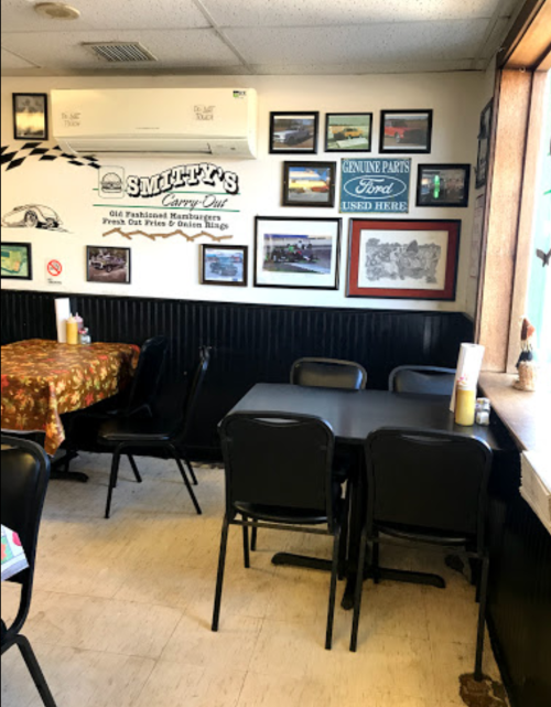 A cozy diner interior with a table, chairs, and walls adorned with framed photos and memorabilia.