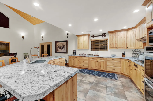Spacious kitchen with wooden cabinets, granite countertops, and modern appliances, featuring a cozy dining area.