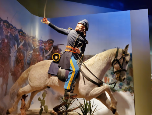 A mounted soldier in uniform brandishes a sword, set against a backdrop of historical military imagery.
