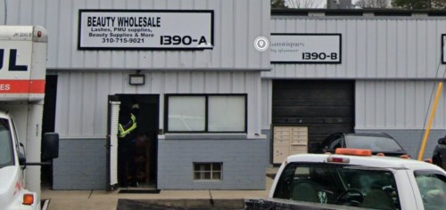 Exterior of a beauty wholesale store with signs for "Beauty Wholesale" and "Antiques by Quinne," featuring a delivery truck.