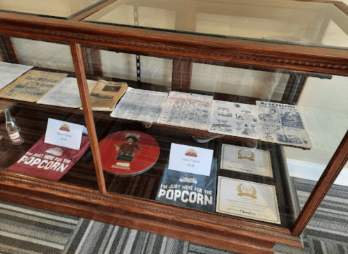 Display case featuring historical documents, certificates, and memorabilia related to popcorn.