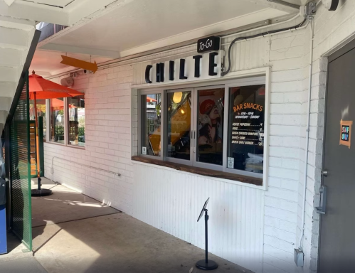 Exterior view of a restaurant named "Chilte," featuring a takeout window and outdoor seating area.