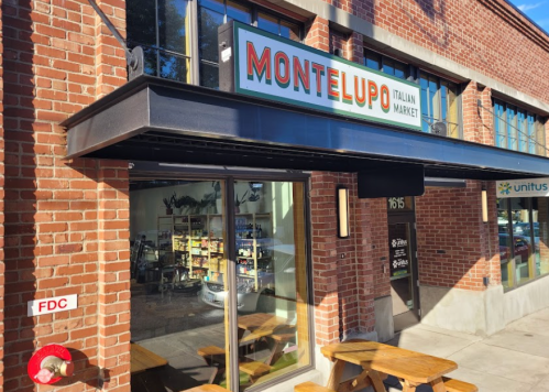 Exterior of Montelupo Italian Market, featuring a brick facade and large windows, with outdoor seating visible.