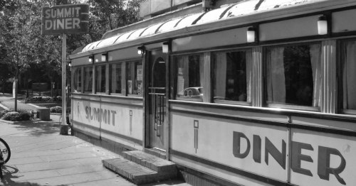 Black and white image of the Summit Diner, featuring a classic diner exterior with large windows and a sign.