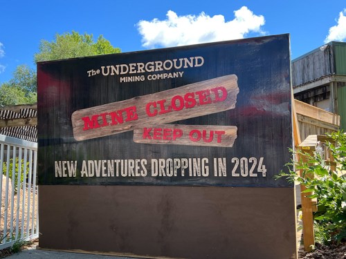 Sign reading "Mine Closed, Keep Out" with a message about new adventures coming in 2024, set against a blue sky.
