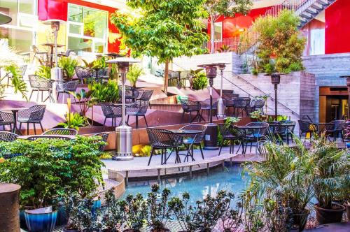 A vibrant outdoor space with a pool, surrounded by greenery, seating areas, and modern decor.