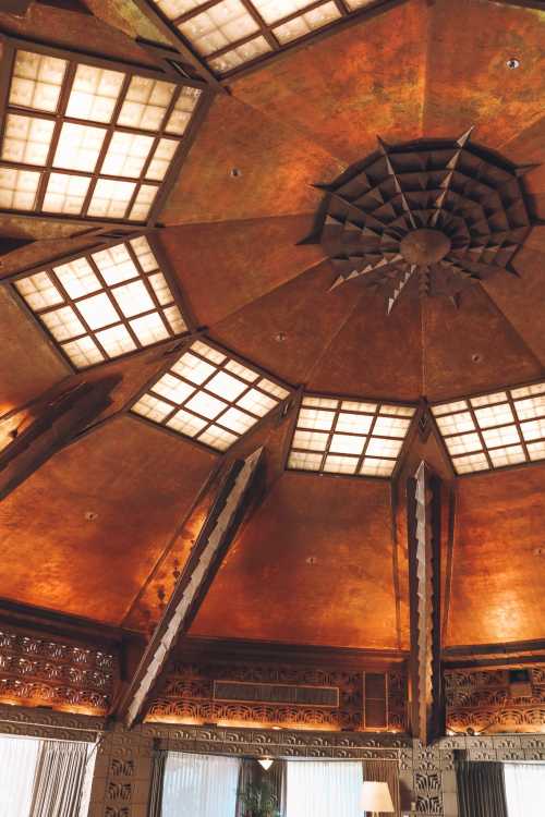 Artistic ceiling with geometric patterns and warm tones, featuring intricate designs and a star-like centerpiece.