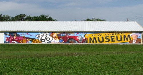 Colorful mural of the D.W. Correll Museum featuring vintage cars and Route 66 imagery on a building exterior.