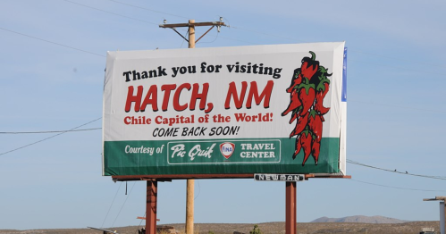 Billboard thanking visitors for Hatch, NM, the "Chile Capital of the World," encouraging them to return soon.