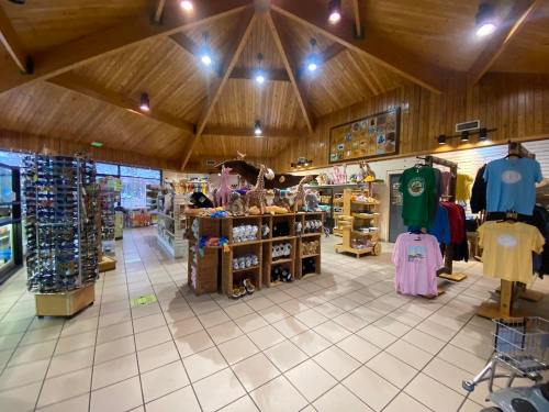 Interior of a gift shop featuring wooden decor, shelves of merchandise, and displays of clothing and souvenirs.