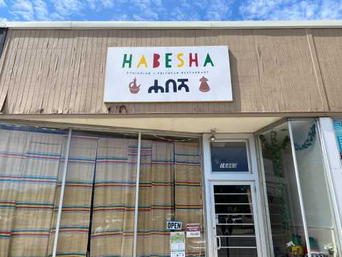 Exterior of Habesha Ethiopian and Eritrean restaurant, featuring a colorful sign and an open door.