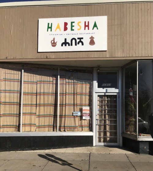Exterior of Habesha, an Ethiopian and Eritrean restaurant, featuring a sign and covered windows.