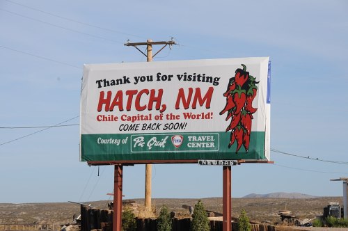 Billboard thanking visitors for Hatch, NM, the "Chile Capital of the World," encouraging them to return soon.