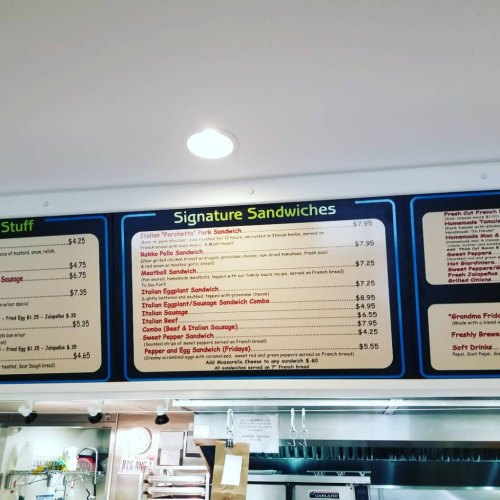 Menu board displaying various signature sandwiches with prices, including options like pork, chicken, and beef sandwiches.