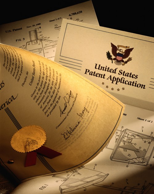 Close-up of a United States patent application with a gold seal and detailed diagrams, showcasing innovation and design.