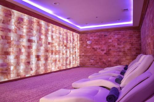 A serene spa room with salt brick walls, soft lighting, and reclining lounge chairs.