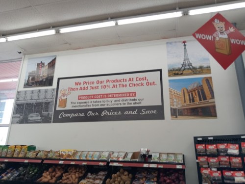 Sign in a store promoting low prices: "We price our products at cost, then add just 10% at checkout. Compare our prices and save."