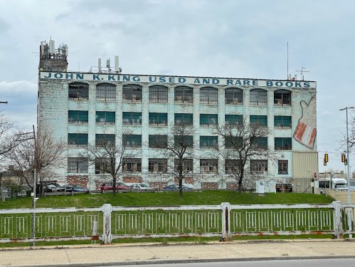 A large, weathered building with "John K. King Used and Rare Books" painted on the side, surrounded by bare trees.