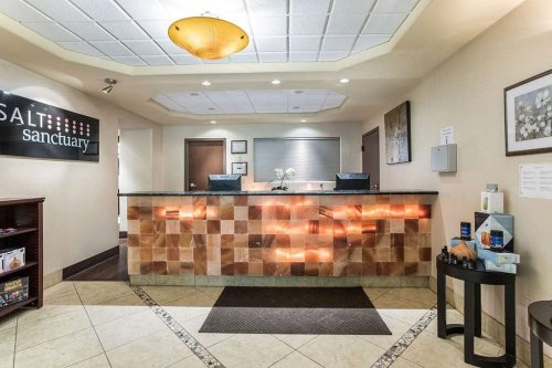A welcoming reception area with a salt wall, soft lighting, and a modern desk at Salt Sanctuary.