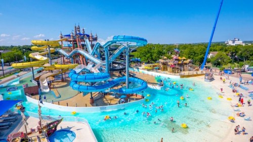 A vibrant water park featuring colorful slides, a lazy river, and families enjoying the sunny day.