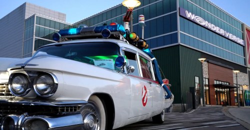 A vintage ghost-themed car with lights parked outside a building labeled "Wonderverse."