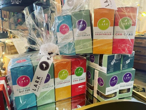 A colorful display of Lark brand treats, including coconut butter, shortbread, and chocolate cha-chas, wrapped in cellophane.