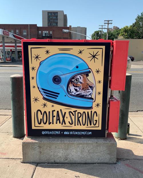 Colorful mural featuring a tiger in a blue helmet with the text "COLFAX STRONG" on a utility box.