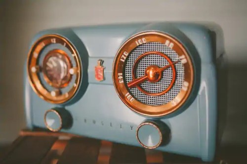 A vintage blue radio with gold accents and dials, featuring a retro design and mesh speaker grilles.