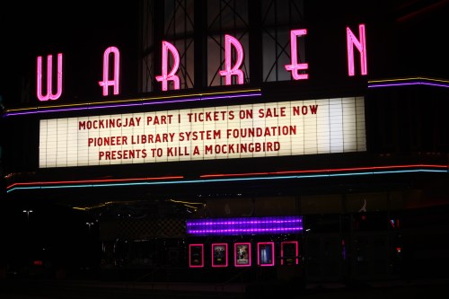 Marquee of the Warren Theater announcing "Mockingjay Part 1" tickets and a presentation of "To Kill a Mockingbird."