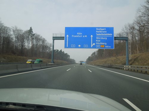 Highway sign indicating directions to Stuttgart, Heilbronn, Würzburg, and other cities, with a clear road ahead.