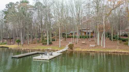 A serene lakeside view featuring a wooden dock, surrounded by trees and a cozy cabin in the background.