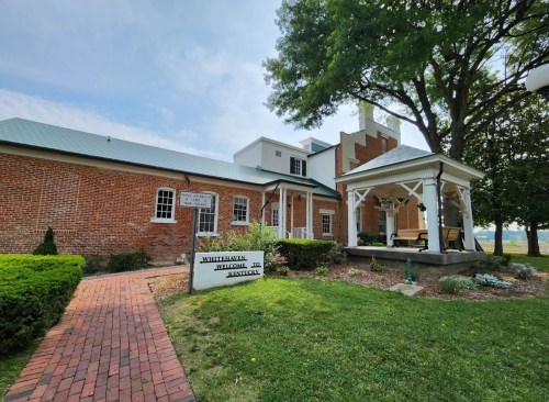 Historic brick building with a gazebo and landscaped lawn, labeled "Whitehaven Welcome Center, Kentucky."