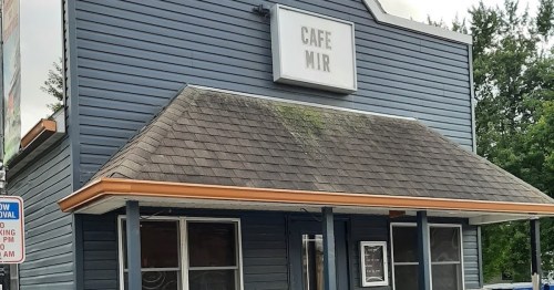A blue building with a sloped roof and a sign reading "Cafe Mir" above the entrance.