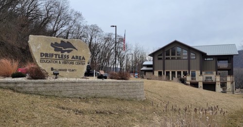 Sign for Driftless Area Education & Visitors Center with a modern building and landscaping in a natural setting.