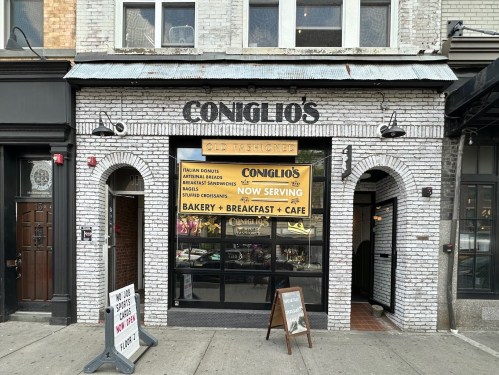 Exterior of Conglio's, a brick restaurant featuring a sign for breakfast, bakery, and café services.