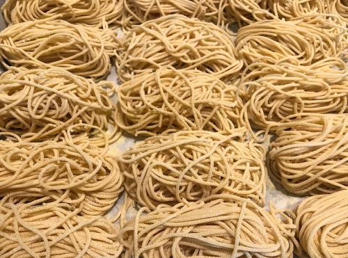 A close-up of neatly arranged bundles of uncooked pasta on a surface.