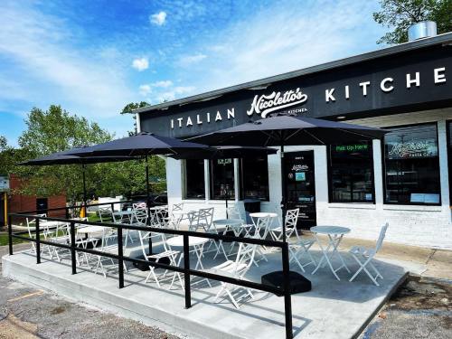 Exterior of Nicoletto's Italian Kitchen with outdoor seating and umbrellas on a sunny day.